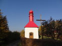 Kaplička Pastviny s jednoduchým dřevěným křížem.